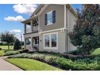 Charming two-story home with a covered porch, well-maintained landscaping, and a mix of textures at 11158 Hollow Bay Dr, Winter Garden, FL 34787