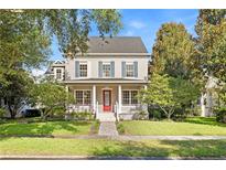 Charming two-story home featuring a inviting front porch, well-manicured lawn and mature trees at 11333 Camden Park Dr, Windermere, FL 34786