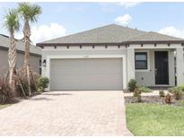 Beautiful single-Gathering home boasts a brick paved driveway and a neutral gray exterior at 1328 Lombardi Ct, Poinciana, FL 34759