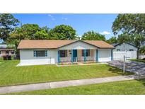 Charming single-story home featuring a well-maintained lawn, and a quaint front porch with blue accents at 1328 S Oxalis Ave, Orlando, FL 32807