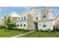 Charming two-story home featuring a modern design, stone accents, well-maintained landscaping and a neatly manicured lawn at 2850 Bookmark Dr, Kissimmee, FL 34746