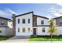 Contemporary two-story home with a modern design, featuring sleek lines, a stone accent wall, and well-manicured landscaping at 2907 Fable St, Kissimmee, FL 34746