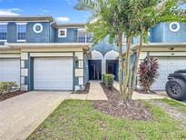 Charming townhouse exterior with a two-car garage, arched entry, and well-maintained landscaping at 3559 Victoria Pines Dr # 280, Orlando, FL 32829