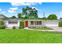 Charming single-story home with well-manicured lawn and bright orange front door at 3716 Neptune Dr, Orlando, FL 32804