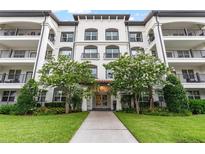 Beautiful condo building featuring a well-maintained lawn and flowering trees at 4001 Breakview Dr # D409, Orlando, FL 32819