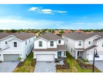 Charming two-story home features a two-car garage, manicured lawn and inviting light blue entry door at 4021 Lana Ave, Davenport, FL 33897