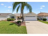 Charming single-story home featuring a well-maintained lawn and a two-car garage, offering curb appeal and convenience at 449 Timmonsville Way, The Villages, FL 32162