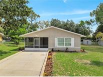 Charming single-story home featuring a screened porch, well-maintained lawn, and tidy landscaping at 458 Spring Ln, Ocala, FL 34472