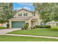 Charming two-story home with a well-maintained lawn and mature trees offering curb appeal at 4901 Stone Acres Cir, St Cloud, FL 34771