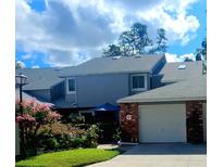 Two-story home featuring a brick one car garage and flower beds lining the front at 525 Oak Ter # 117, Altamonte Springs, FL 32701
