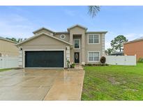Charming two-story home with a well-maintained lawn and a two-car garage at 605 Elbridge Dr, Kissimmee, FL 34758