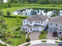 Beautiful two-story home with a pond view, landscaped yard, and a two-car garage at 6905 Cucamelon Ct, Windermere, FL 34786