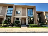 Modern two-story townhome featuring large windows and manicured landscaping in a desirable community at 7528 Brooklyn Dr, Kissimmee, FL 34747