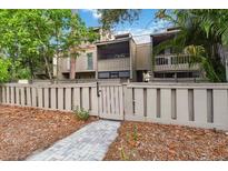 Townhouse exterior with wood fence, leafy trees, and walkway leading to front doors at 108 Crown Oaks Way, Longwood, FL 32779