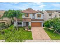 Charming two-story home with manicured lawn, a brick driveway, and tan trim at 1270 Fountain Coin Loop, Orlando, FL 32828