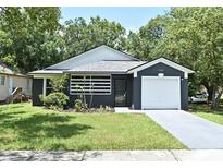 Charming single-story home with a well-manicured lawn and a one-car garage, set amidst lush green trees at 1502 W 16 Th Street, Sanford, FL 32771