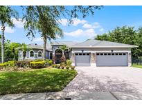 Charming single-story home with a manicured lawn, mature landscaping, and a three-car garage at 1640 Wild Indigo Ter, Oviedo, FL 32766