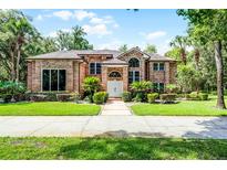 Beautiful brick home featuring a meticulously maintained lawn and mature landscaping at 1717 Fountainhead Dr, Lake Mary, FL 32746