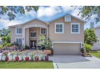 Inviting two-story home featuring a well-maintained yard and charming architectural details at 1731 Knotting Hill Dr, Orlando, FL 32835