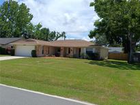 Charming single-story home with a well-manicured lawn, stone accents, and attached garage at 2414 Willow Oak Dr, Edgewater, FL 32141