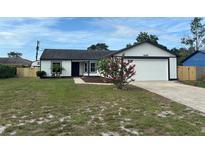 Charming single-story home with a well-maintained lawn and an attached two car garage at 3055 Kirkland St, Deltona, FL 32738