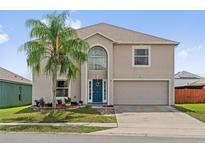 Charming two-story home featuring a well-maintained lawn, a large palm tree, and a two-car garage at 328 Fairfield Dr, Sanford, FL 32771