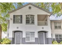 Charming condo featuring a white stucco exterior, gray accents, and a cozy second-story balcony at 4356 S Kirkman Rd # 514, Orlando, FL 32811