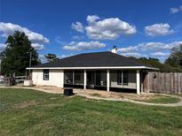 Cozy single-story home featuring a screened porch and freshly cut green lawn against a cloudy blue sky backdrop at 4805 Sw 171St Ct, Dunnellon, FL 34432