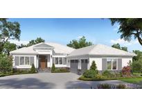 Charming single story home featuring a symmetrical façade, a light colored roof, and lush landscaping at 9517 San Fernando Ct, Howey In The Hills, FL 34737
