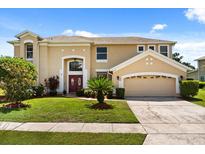 Charming two-story home featuring a well-manicured lawn, beautiful landscaping, and a spacious two-car garage at 13147 Meergate Cir, Orlando, FL 32837