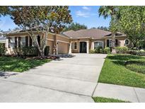 Well-maintained single-story home with a spacious driveway and a manicured lawn at 13943 Caywood Pond Dr, Windermere, FL 34786