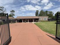 Inviting home with a long driveway, covered parking, well-manicured lawn, and gated entrance for added privacy at 17 E Lake Mary Dr, Orlando, FL 32839