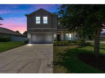 Charming two-story home featuring a well-manicured lawn, driveway, and attached two-car garage at 2560 Hayden Valley Street, Apopka, FL 32703