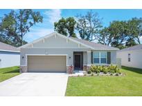 Charming single-story home with a well-manicured lawn, two car garage, and inviting front entrance at 3964 Mayhill Loop, Eustis, FL 32736