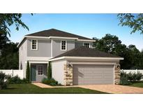 Two-story home with a two-car garage, stone accents, manicured lawn, and a charming, light-gray facade at 406 Cool Summer Ln, Davenport, FL 33837