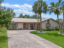 Charming single-story home featuring a beige exterior, metal roof, and a long brick driveway at 708 Duffer Ln, Kissimmee, FL 34759