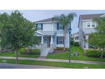 Charming two-story home featuring manicured landscaping, a covered porch, and a neatly maintained lawn at 9069 Pinch Shot Dr, Winter Garden, FL 34787