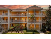 Brightly painted condo building with white railings and lush landscaping shows inviting facade at 1109 New Providence # 141109, Davenport, FL 33897