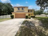 Two-story home with a two car garage, balcony, and well manicured lawn with a blue sky at 281 Covent Gardens Pl, Deltona, FL 32725