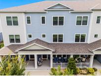 Three-story townhouse featuring a covered front porch, blue siding, and white trim at 461 Diamond Dove Cv, Winter Springs, FL 32708