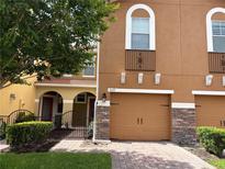 Charming townhome featuring a brick driveway, tan paint and stone accents on the garage at 5377 Via Appia Way, Sanford, FL 32771