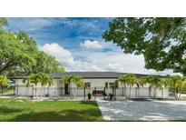 Modern home featuring a fenced front yard, palm trees, and a welcoming paved walkway at 9353 Gotha Rd, Windermere, FL 34786