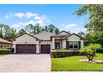 Beautiful single-story home with a three-car garage, well-manicured lawn and charming landscaping at 100 Verde Way, Debary, FL 32713