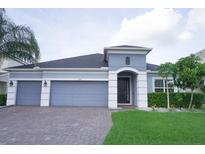 Charming single-story home with a three-car garage and well-maintained landscaping at 14146 Jomatt Loop, Winter Garden, FL 34787