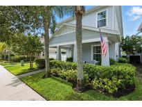 Charming two-story home featuring a cozy front porch, manicured lawn, and vibrant landscaping at 16262 Firedragon Dr, Winter Garden, FL 34787