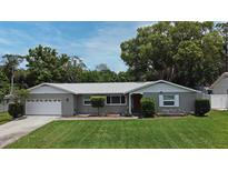 Charming single-story home featuring a well-manicured lawn, gray painted brick, white trim, and beautiful curb appeal at 2430 Westwood Dr, Longwood, FL 32779