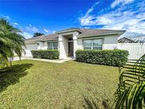 Charming single-story home featuring manicured landscaping, a well-maintained lawn, and a welcoming entrance at 425 Cardinal Ct, Poinciana, FL 34759