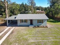 Charming single-story home with a gray roof, wood accents, and freshly landscaped front yard at 611 S Montgomery Ave, Deland, FL 32720