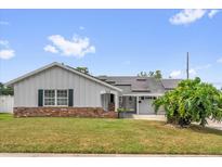 Charming home featuring solar panels, well-maintained lawn, and a brick facade at 317 Benton St, Orlando, FL 32839