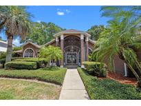 Gorgeous home featuring lush landscaping and an elegant gated entryway and walkway at 6631 Crenshaw Dr, Orlando, FL 32835